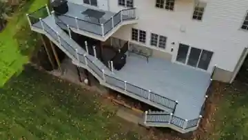 Aerial view of a large composite deck with black aluminum railing and multiple stair sections